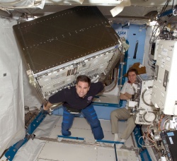 Figure 11.4. Thanks to the weightlessness of space, astronaut Greg Chamitoff easily moves an experiment rack onboard the ISS (Courtesy of NASA).